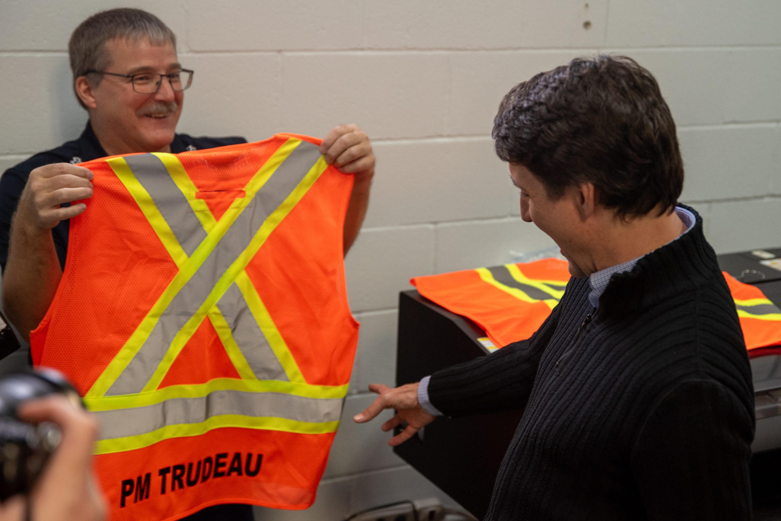 An excited Trudeau was happy to see his name on the back of a high-visibility vest. He quickly turned gift into a political win and said it would be useful to have on all the construction sites he visits as PM.